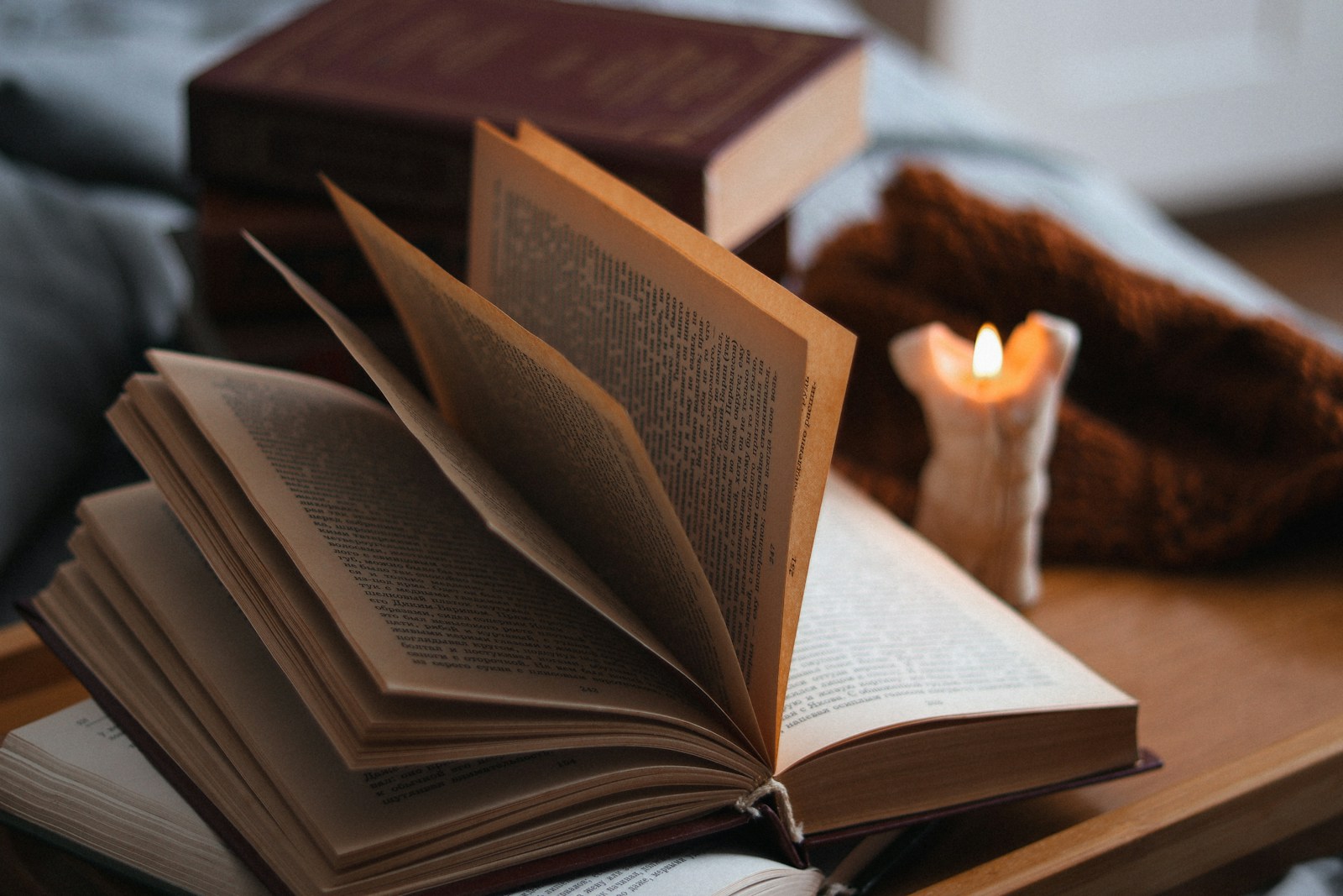 An open book beside a lit candle